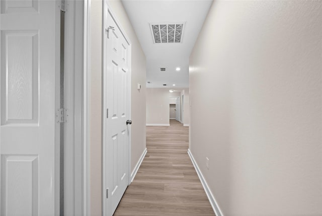 corridor with light hardwood / wood-style floors