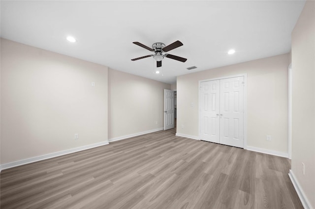 unfurnished bedroom featuring ceiling fan, light hardwood / wood-style floors, and a closet