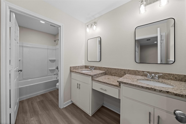 full bathroom with vanity, wood-type flooring, shower / bathtub combination, and toilet