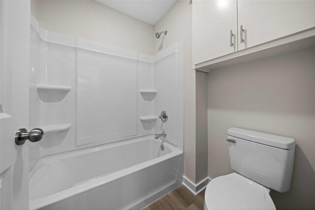 bathroom featuring shower / bathing tub combination, hardwood / wood-style flooring, and toilet