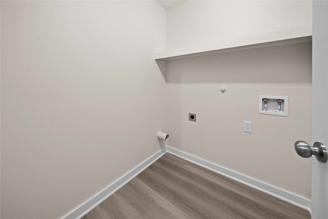 clothes washing area with hardwood / wood-style floors, electric dryer hookup, hookup for a gas dryer, and hookup for a washing machine