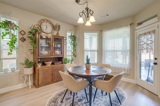 dining area featuring light hardwood / wood-style floors and a notable chandelier