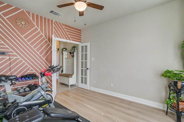 exercise room with ceiling fan, french doors, and light hardwood / wood-style floors