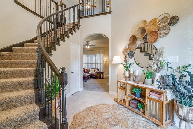 tiled entryway featuring a high ceiling and ceiling fan