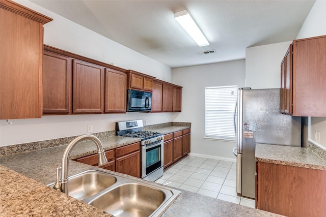 kitchen featuring appliances with stainless steel finishes, sink, and light tile patterned floors