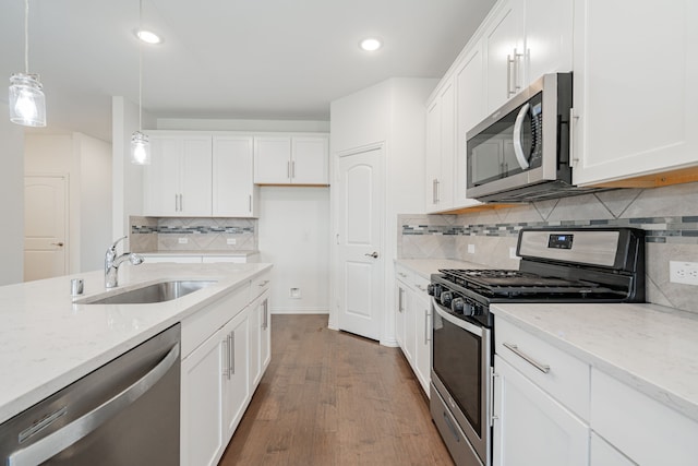 kitchen with white cabinetry, decorative light fixtures, and appliances with stainless steel finishes