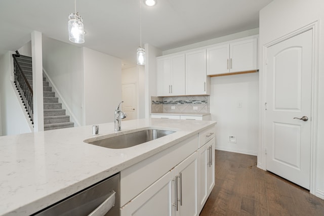 kitchen with pendant lighting, white cabinetry, light stone counters, and sink