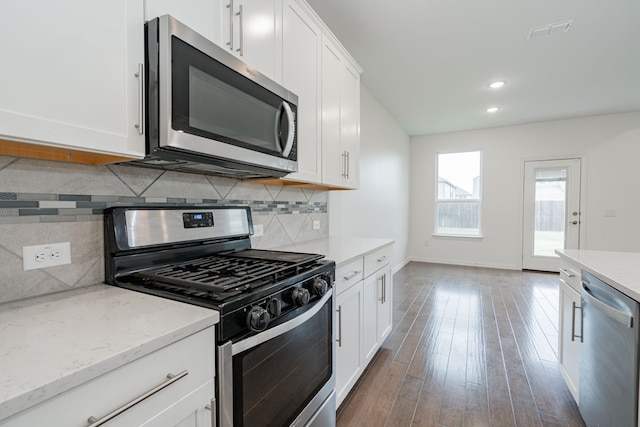 kitchen with light stone counters, white cabinetry, appliances with stainless steel finishes, and tasteful backsplash