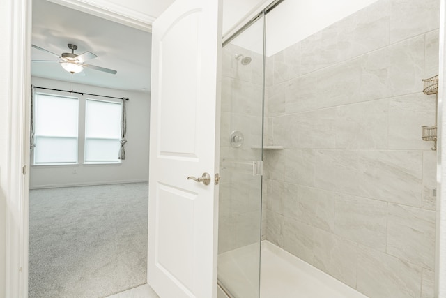 bathroom featuring ceiling fan and an enclosed shower