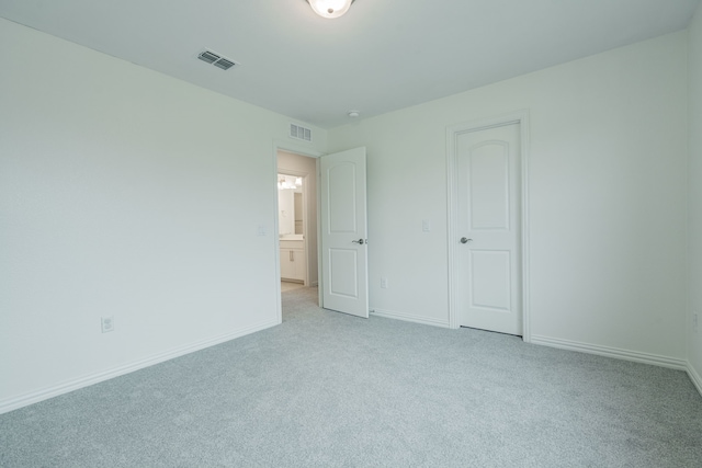 unfurnished bedroom featuring light carpet and a closet