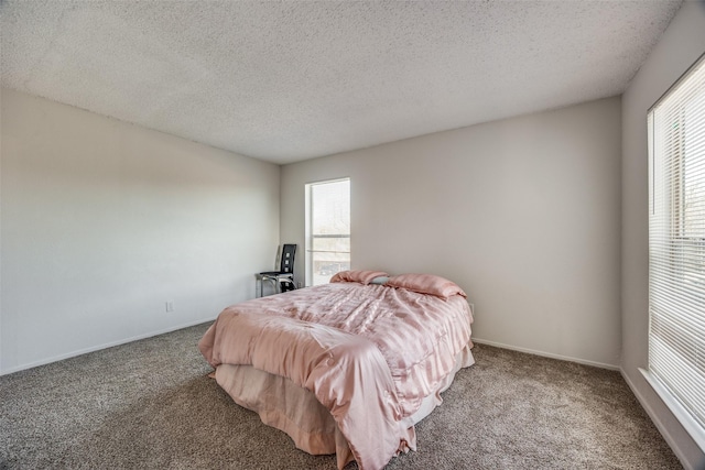 bedroom with carpet flooring, a textured ceiling, and multiple windows