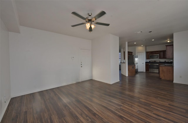 unfurnished living room with ceiling fan, dark hardwood / wood-style flooring, and sink