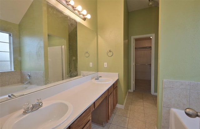 bathroom featuring tile patterned floors, vanity, lofted ceiling, and a bath