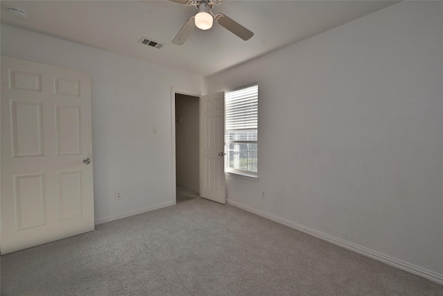 empty room featuring ceiling fan and light colored carpet