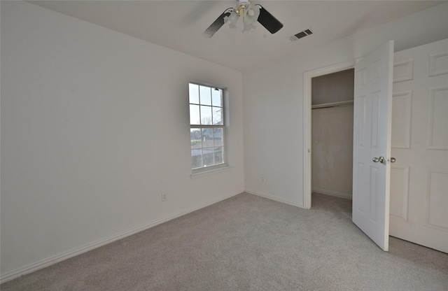 unfurnished bedroom with a closet, light colored carpet, and ceiling fan