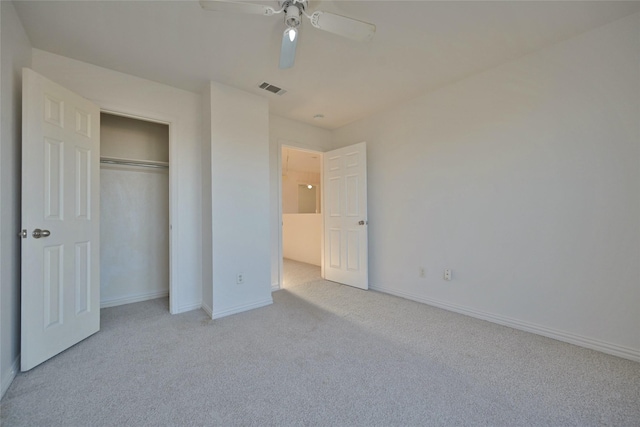 unfurnished bedroom featuring ceiling fan, light colored carpet, and a closet