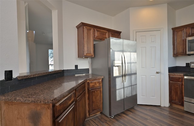 kitchen featuring kitchen peninsula, dark hardwood / wood-style flooring, and stainless steel appliances