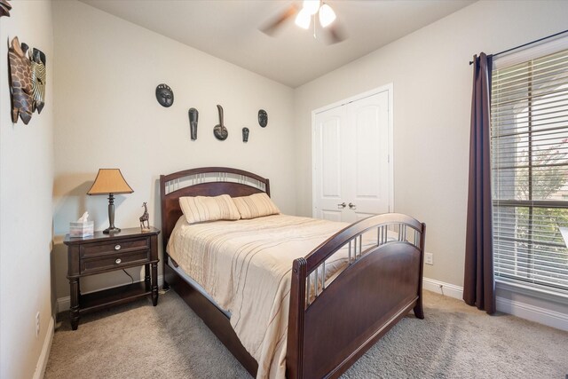 carpeted bedroom with ceiling fan and a closet