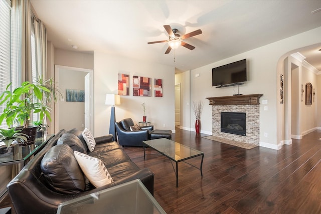 living room with a fireplace, dark hardwood / wood-style flooring, and ceiling fan