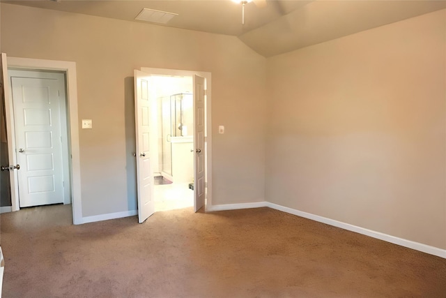 carpeted spare room featuring vaulted ceiling