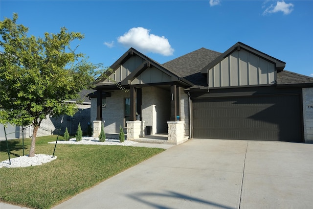 view of front facade with covered porch, a front yard, and a garage