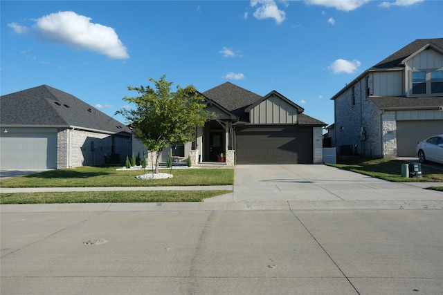 view of front of house featuring a garage, central AC unit, and a front yard