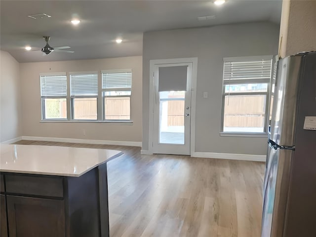 kitchen featuring ceiling fan, stainless steel fridge, vaulted ceiling, and light hardwood / wood-style flooring