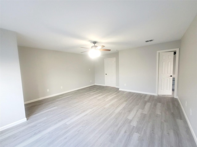 unfurnished room featuring baseboards, visible vents, and light wood-style flooring