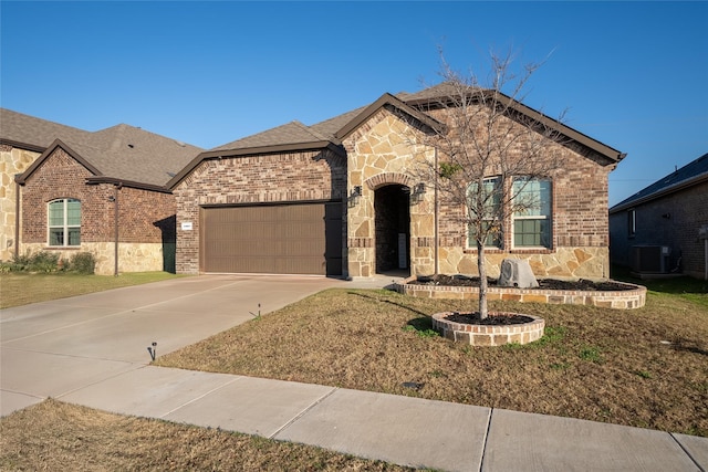 view of front of property featuring central AC and a garage