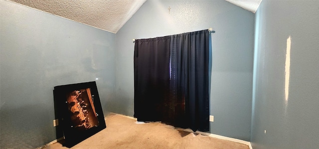 bedroom featuring light colored carpet, a textured ceiling, and vaulted ceiling