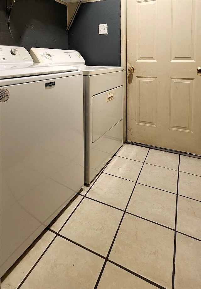 clothes washing area with light tile patterned flooring and washing machine and dryer