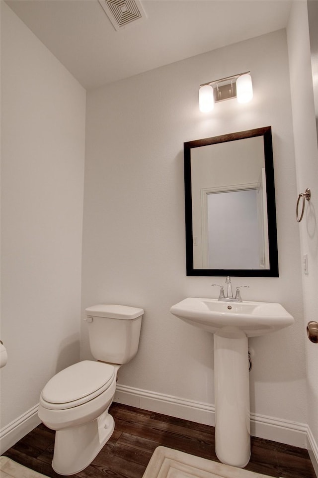 bathroom with hardwood / wood-style floors and toilet