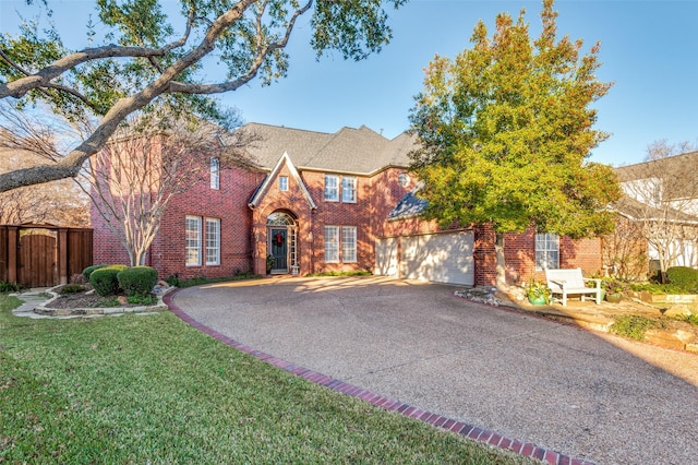 english style home with a front yard and a garage