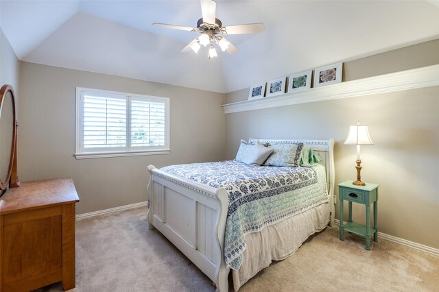 carpeted bedroom with ceiling fan and vaulted ceiling