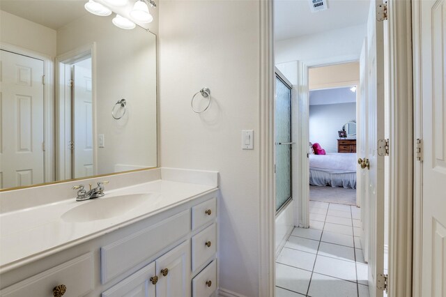 bathroom with tile patterned flooring, vanity, and enclosed tub / shower combo