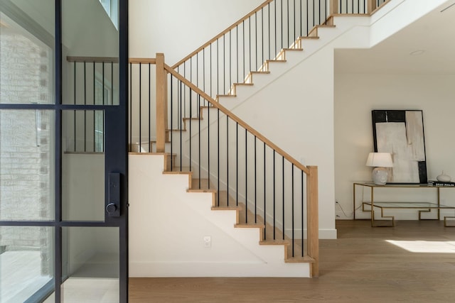 stairway featuring a healthy amount of sunlight and hardwood / wood-style floors