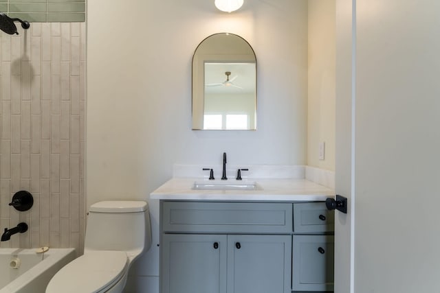 full bathroom featuring vanity, tiled shower / bath, and toilet