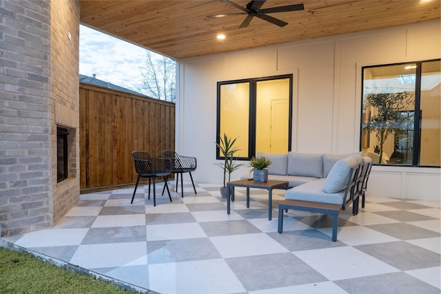 view of patio / terrace with an outdoor living space with a fireplace and ceiling fan