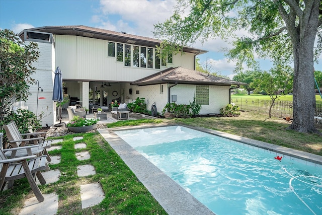 view of swimming pool featuring a yard, an outdoor hangout area, a patio, and ceiling fan