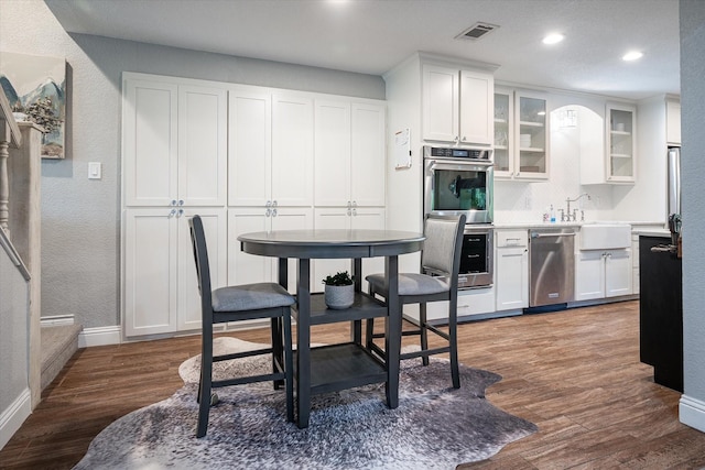 kitchen featuring white cabinetry, sink, dark hardwood / wood-style floors, and appliances with stainless steel finishes