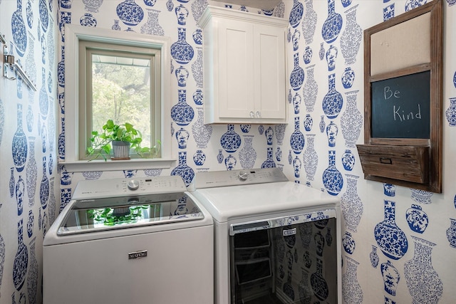 clothes washing area with cabinets and washing machine and clothes dryer