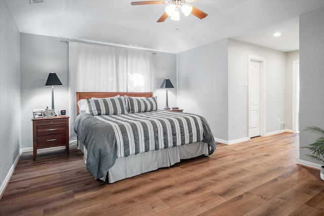 bedroom featuring a tray ceiling, ceiling fan, and hardwood / wood-style floors