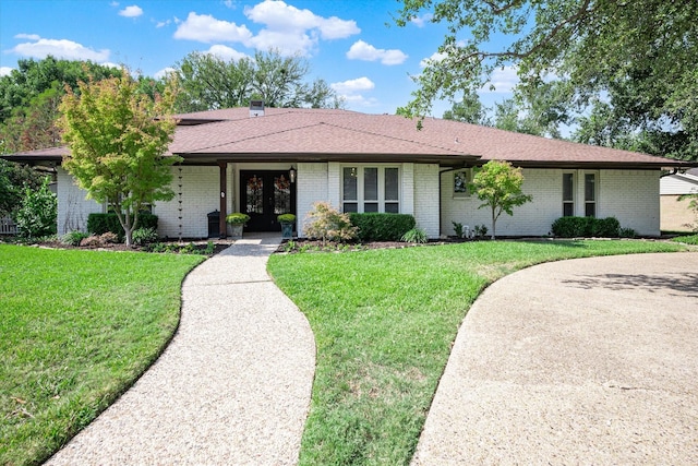 ranch-style home with a front yard and french doors