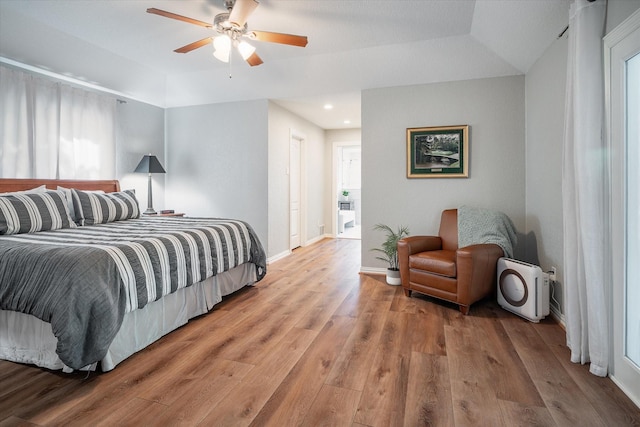 bedroom featuring hardwood / wood-style flooring, ceiling fan, and multiple windows