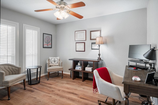 office with light hardwood / wood-style flooring and ceiling fan