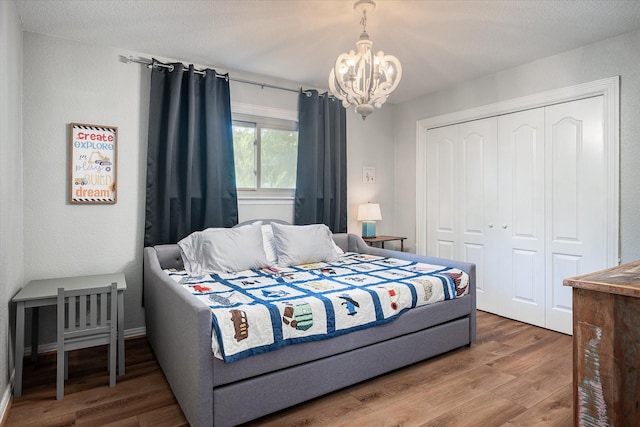 bedroom with a chandelier, hardwood / wood-style flooring, and a closet