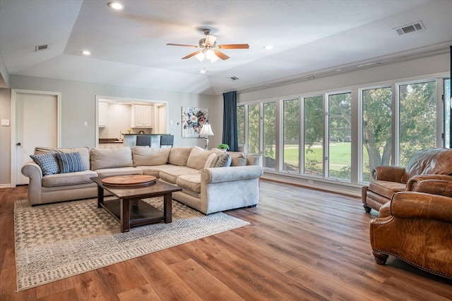 living room with hardwood / wood-style floors, vaulted ceiling, and ceiling fan