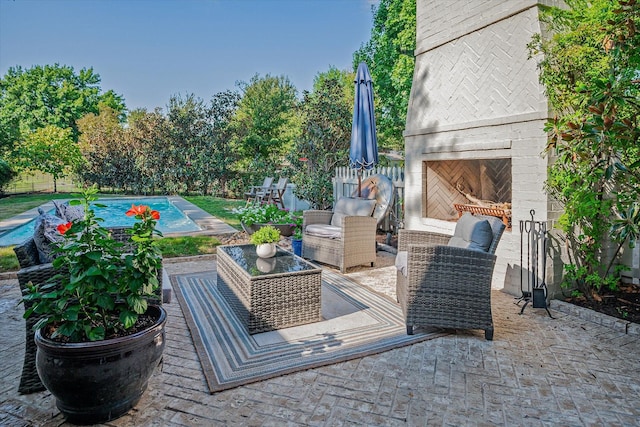 view of patio / terrace featuring a fenced in pool and an outdoor brick fireplace