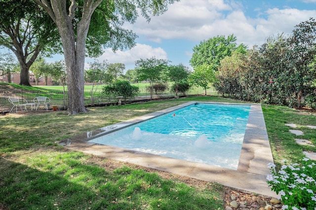 view of swimming pool featuring a yard