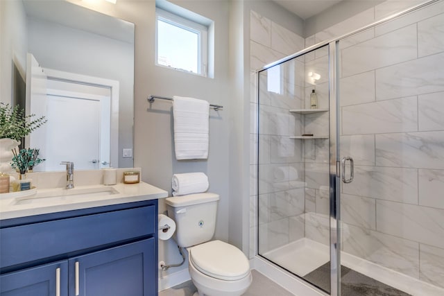 bathroom featuring vanity, toilet, and a shower with door